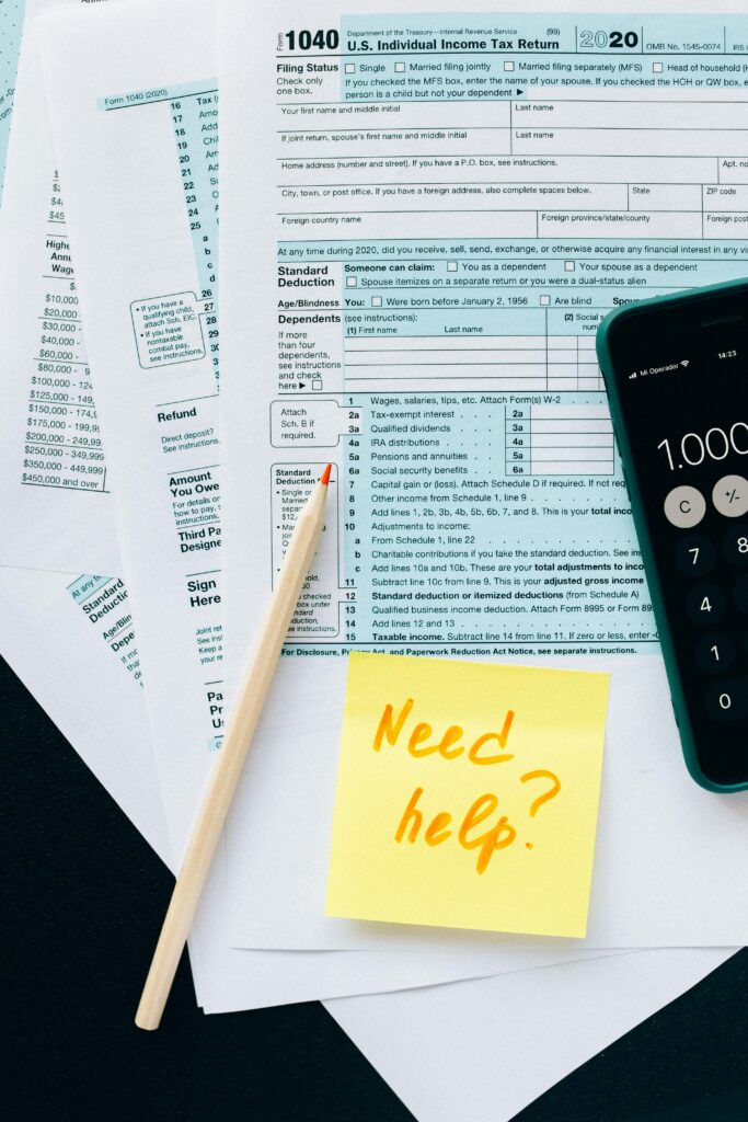 pexels photo 6863250 6863250 Close-up of tax forms with a calculator and a note asking for assistance.